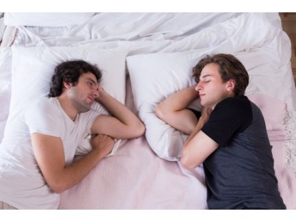 男性同士がベッドで寝ている写真