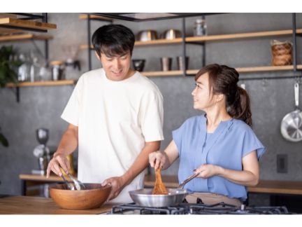 料理するカップルの写真