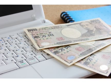 PCの上に1万円札が置いてある写真